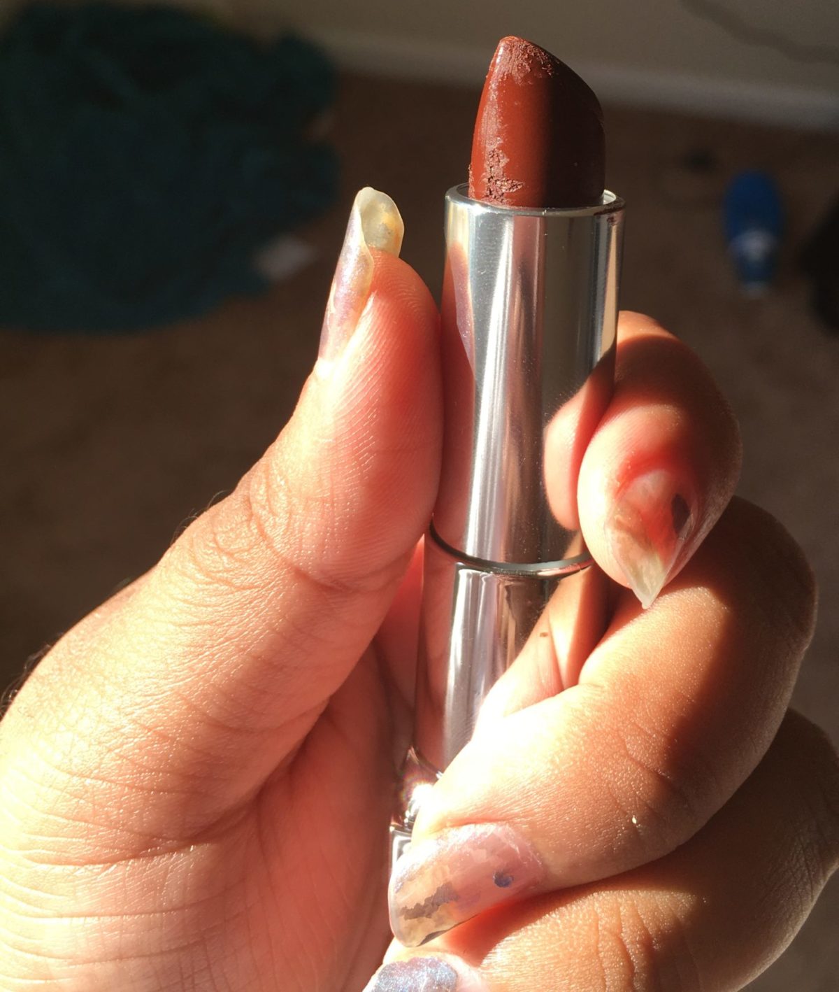 a hand holds lipstick
